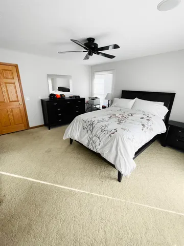 a bedroom with a bed and a ceiling fan