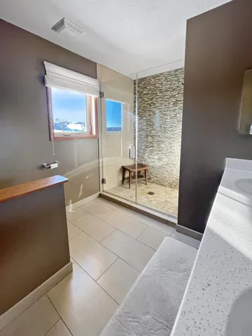 a spacious bathroom with a double vanity sink a mirror and a shower