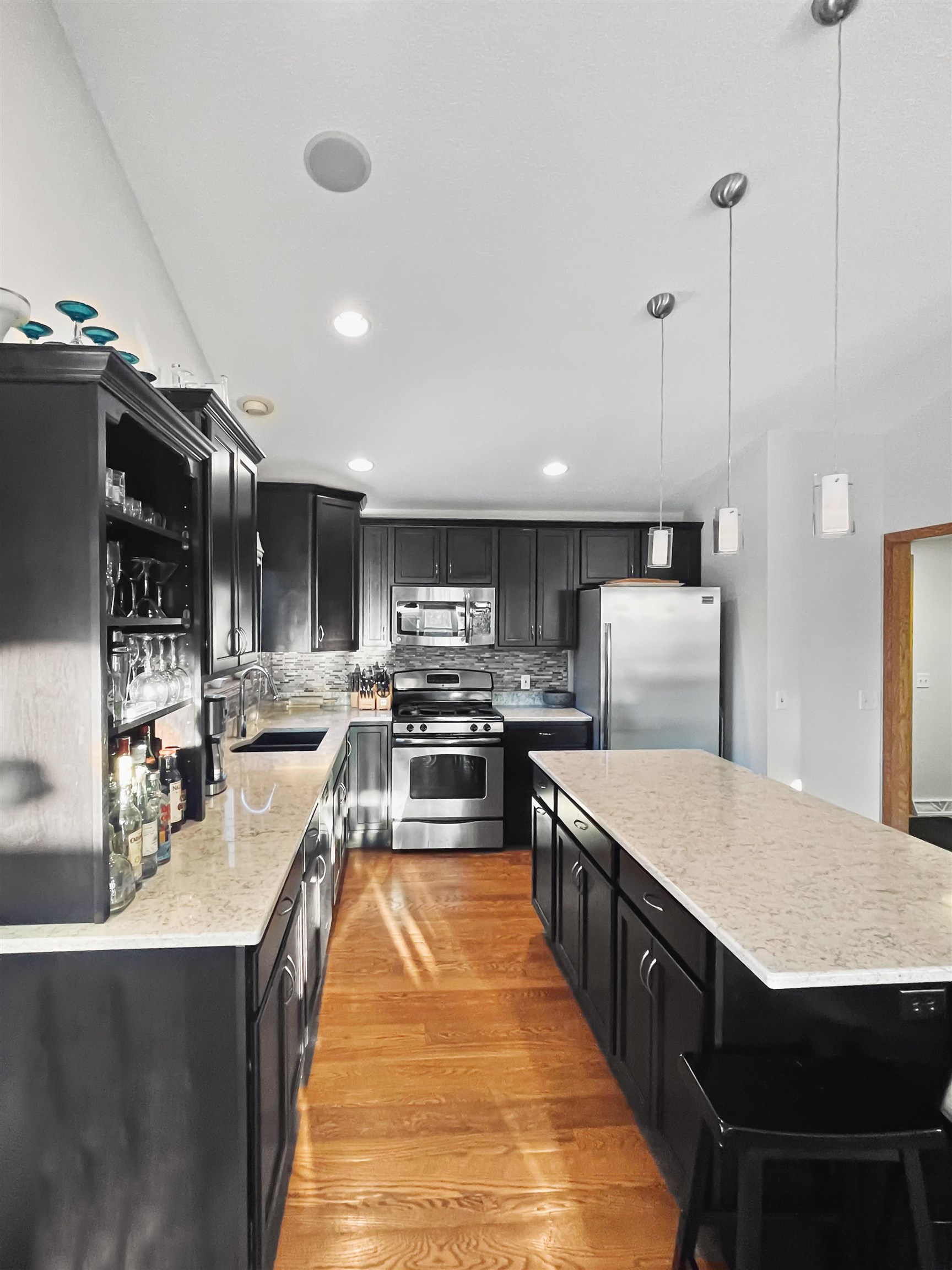 27-54 Ridgeview Drive Lake Carroll, IL 61046 - Photo 31 of 58 a large kitchen with kitchen island a stove a sink a refrigerator and a dining table with wooden floor