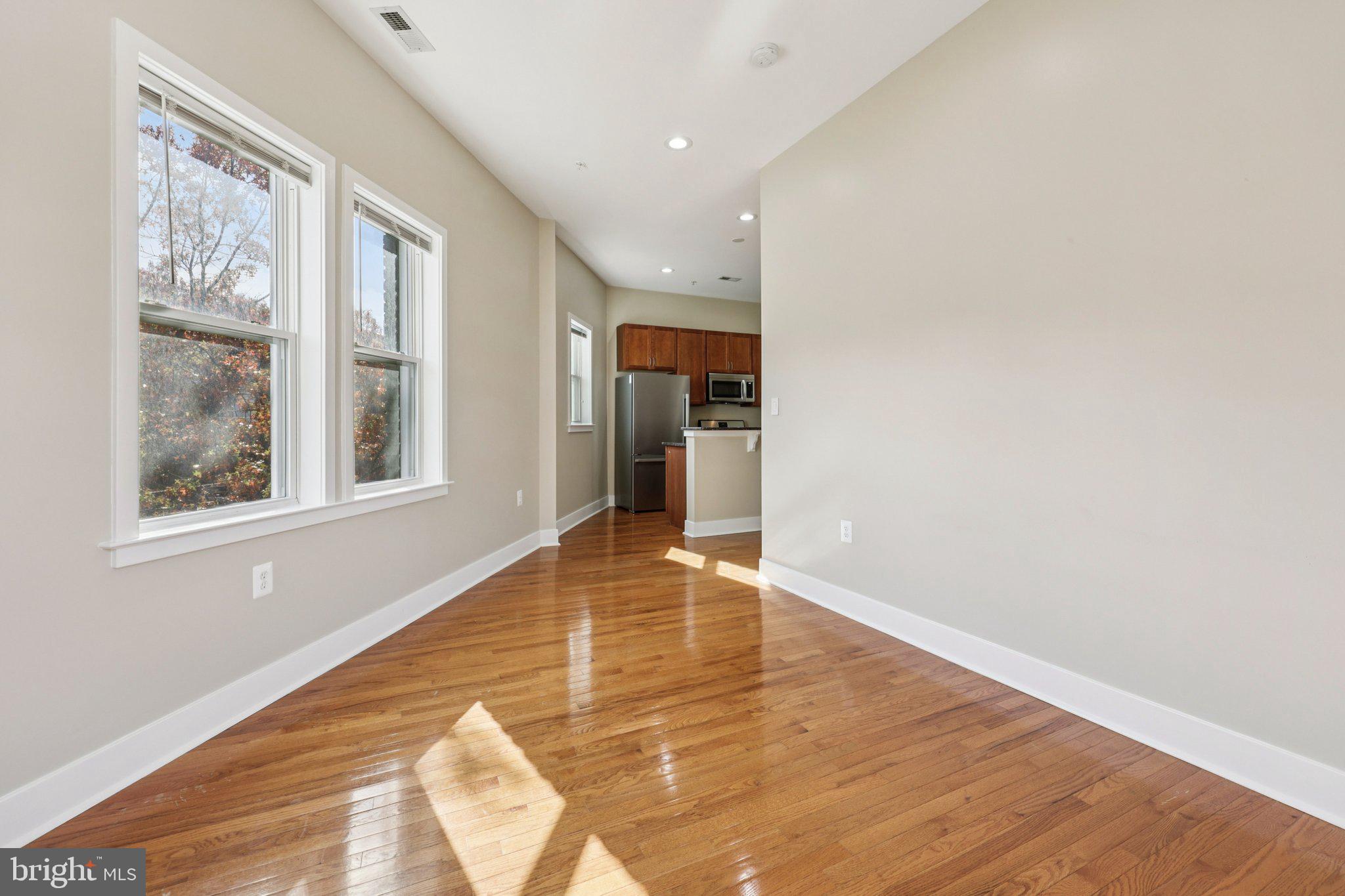 1352 Longfellow Street Northwest, Unit 302 Washington, DC 20011 - Photo 7 of 24 a view of an empty room with wooden floor and a window