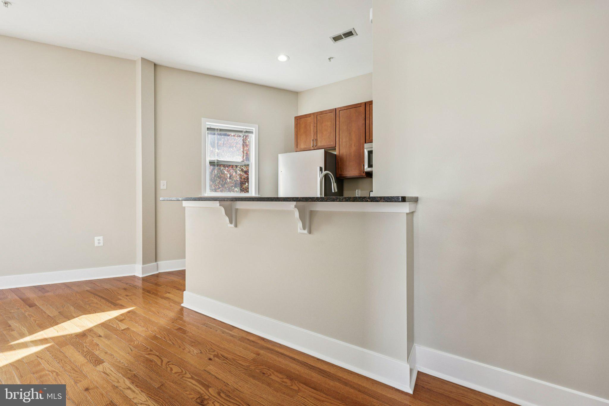 1352 Longfellow Street Northwest, Unit 302 Washington, DC 20011 - Photo 8 of 24 a view of a kitchen with wooden floor and cabinet