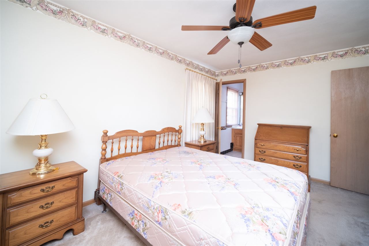4228 Pinecrest Road Rockford, IL 61107 - Photo 18 of 30 a bedroom with a bed and a chandelier