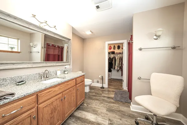 a bathroom with a granite countertop sink mirror vanity and toilet