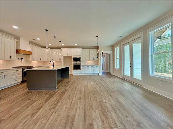 a large kitchen with stainless steel appliances kitchen island a large counter top and a wooden floors