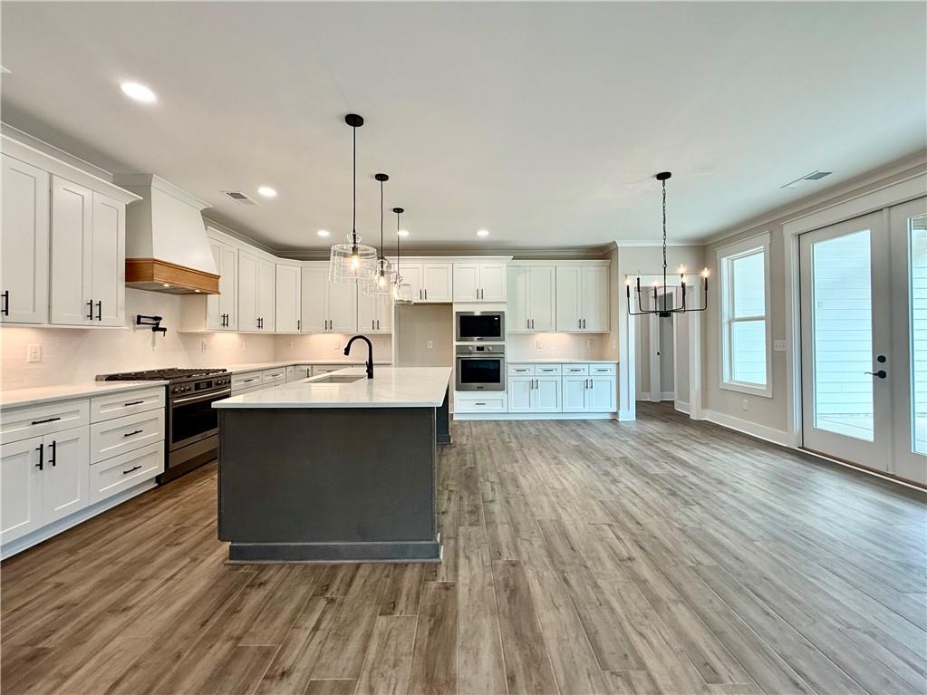141 Palisade Drive Rydal, GA 30171 - Photo 15 of 50 a kitchen with wooden floors and white cabinets