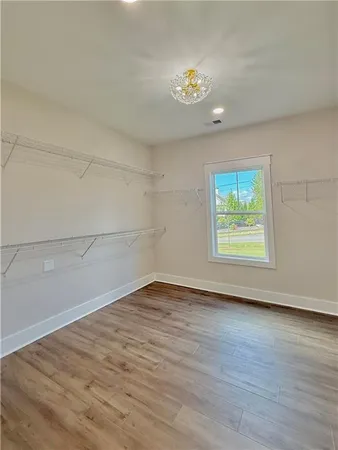 an empty room with wooden floor and window