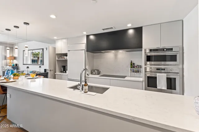 a kitchen with stainless steel appliances a stove sink and microwave
