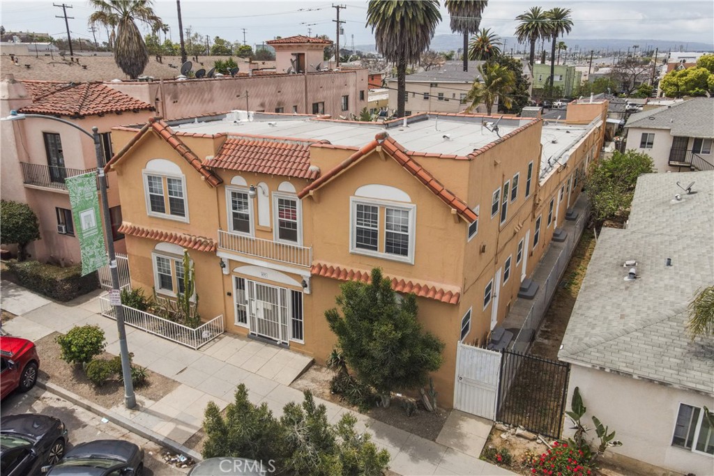 a view of a white house with a large windows and palm trees