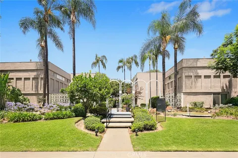 a front view of a multi story residential apartment building with yard and green space