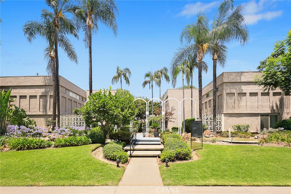 a front view of a multi story residential apartment building with yard and green space