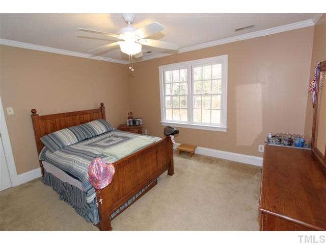 12016 Deer Run Raleigh, NC 27614 - Photo 13 of 23 a bedroom with a bed and a chandelier
