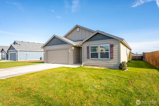 a front view of a house with yard and garage