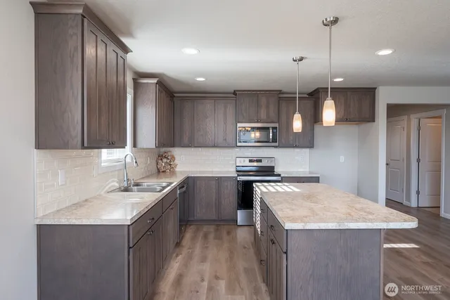 a kitchen with a sink a stove a refrigerator and cabinets