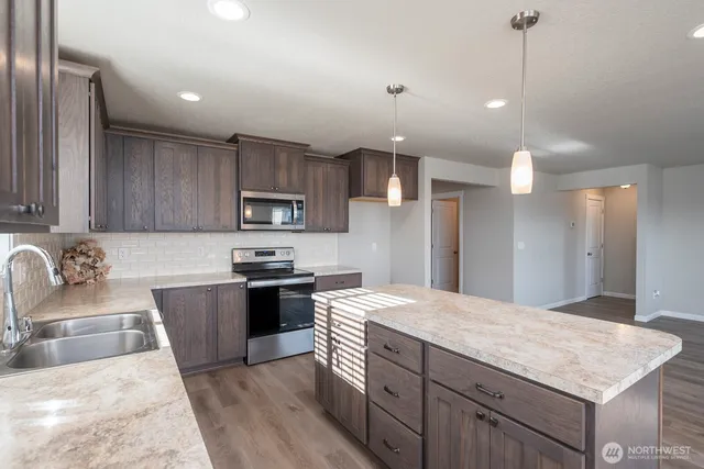 a kitchen with stainless steel appliances granite countertop a sink stove and refrigerator