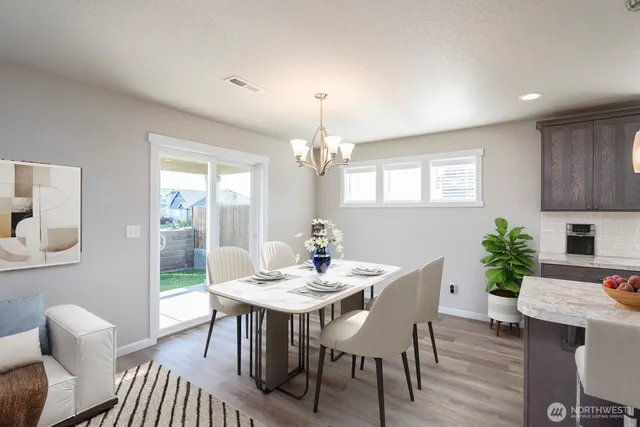 a dining room with furniture potted plants and wooden floor