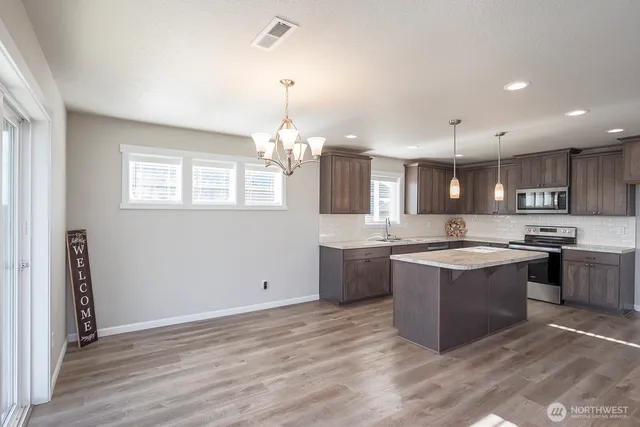 a large kitchen with kitchen island a sink stainless steel appliances and cabinets