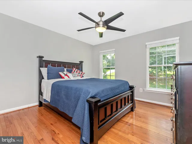 a bedroom with a bed and a ceiling fan