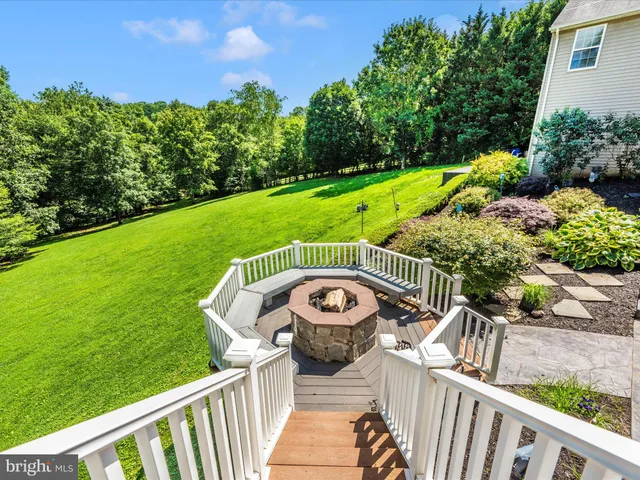 a view of a wooden deck with couches and a yard