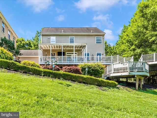 a view of backyard with large tree and wooden fence