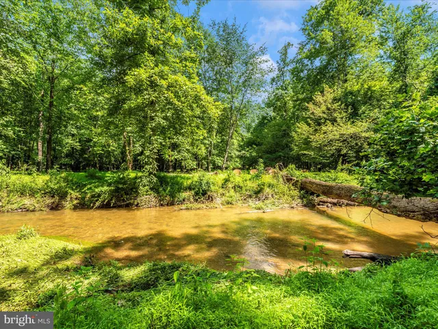 a kitchen with stainless steel appliances granite countertop a kitchen island a stove a table and chairs