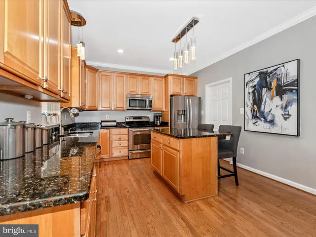 a kitchen with stainless steel appliances granite countertop a stove a sink dishwasher and a refrigerator