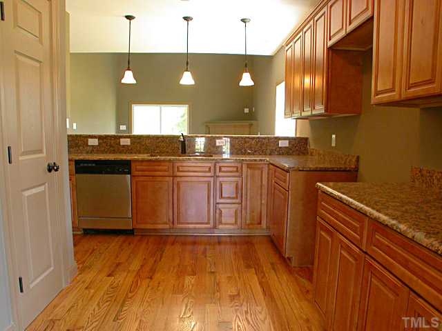 4626 Pat Reed Road Raleigh, NC 27616 - Photo 3 of 20 a kitchen with stainless steel appliances granite countertop a sink a stove and a wooden floors
