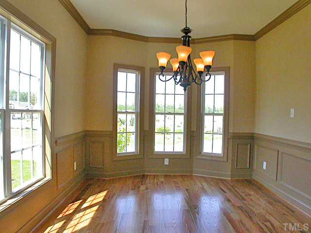 4626 Pat Reed Road Raleigh, NC 27616 - Photo 5 of 20 a view of an empty room with wooden floor and a window