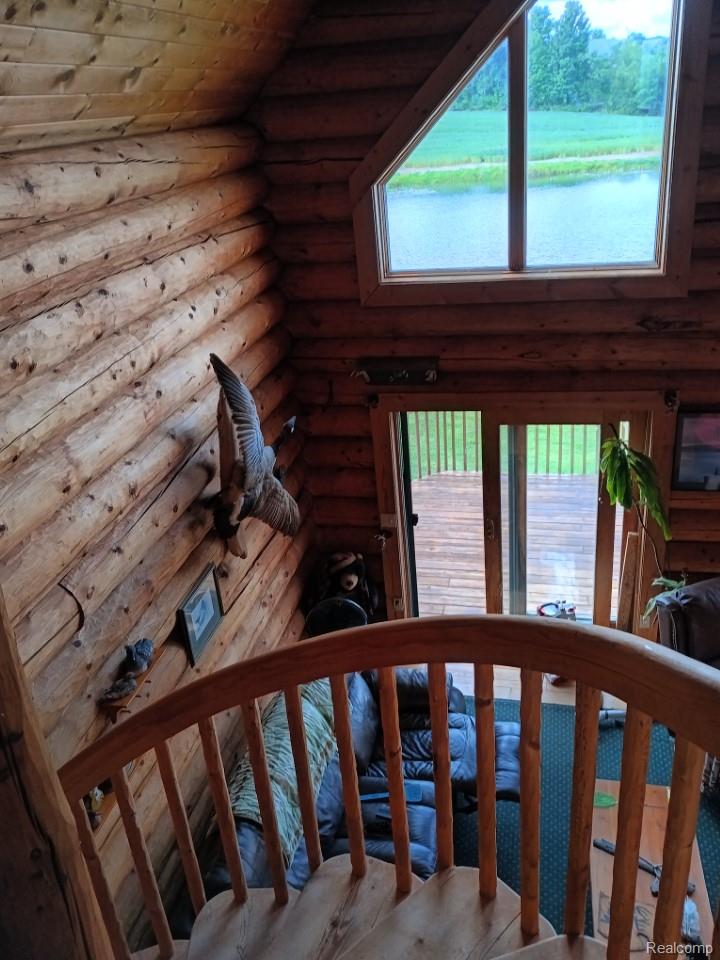 10374 Wilson Road Otisville, MI 48463 - Photo 41 of 99 Stairway featuring rustic walls, a water view, and wooden ceiling
