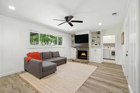 a living room with furniture a fireplace and a flat screen tv