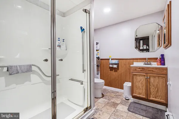 a bathroom with a sink a toilet and shower
