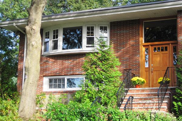 2 Wickham Road Winchester, MA 01890 - Photo 3 of 16 front view of a brick house with a large window and potted plants