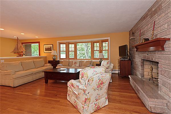 2 Wickham Road Winchester, MA 01890 - Photo 8 of 16 a living room with furniture a large window and a fireplace