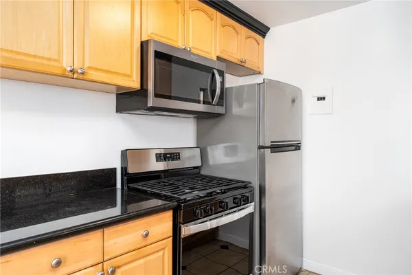 a kitchen with stainless steel appliances granite countertop a stove microwave and refrigerator