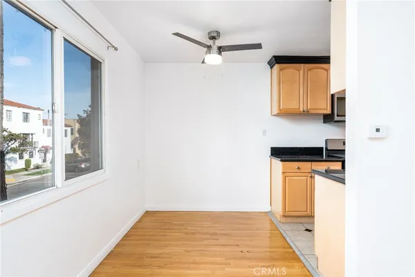 a view of a room with a ceiling fan and wooden floor