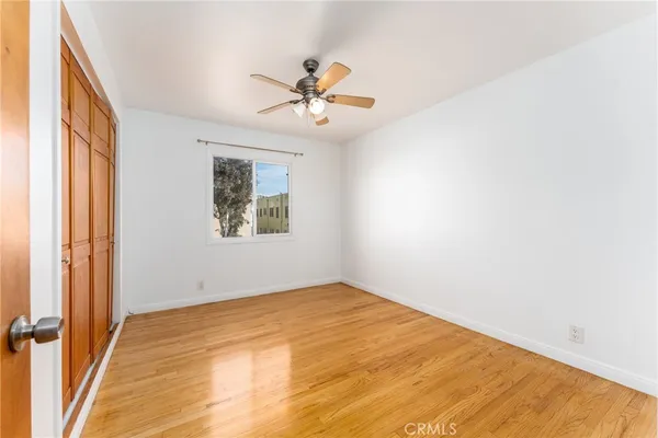 an empty room with windows and fan