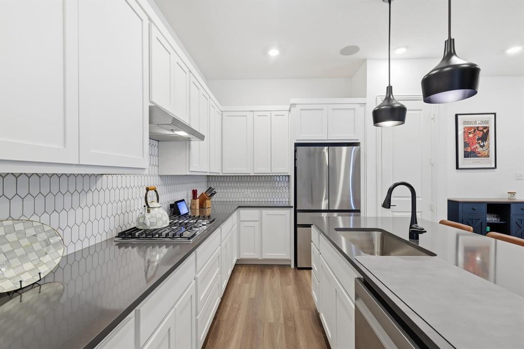 2331 Jack Rabbit Way Northlake, TX 76247 - Photo 16 of 38 a kitchen with stainless steel appliances granite countertop a sink dishwasher a stove and a refrigerator with wooden cabinets