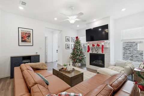 a living room with furniture a flat screen tv and a fireplace