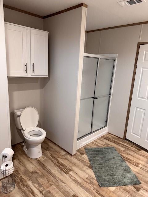 6218 Cr-4813 Pecan Gap, TX 75469 - Photo 21 of 30 Bathroom with wood finished floors, visible vents, a stall shower, ornamental molding, and toilet