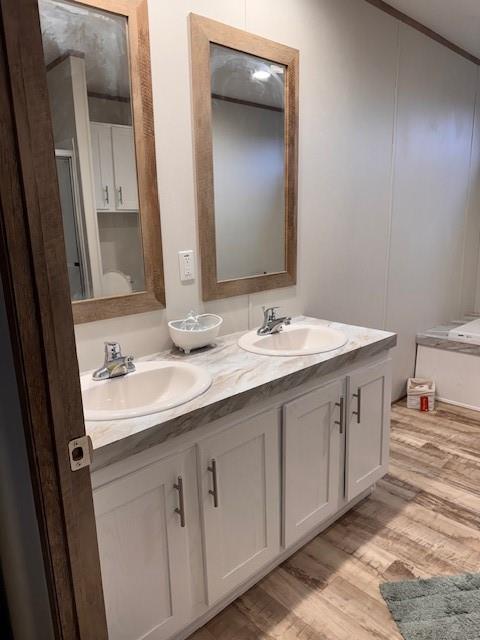 6218 Cr-4813 Pecan Gap, TX 75469 - Photo 22 of 30 Bathroom with a sink, wood finished floors, and double vanity