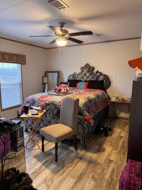 6218 Cr-4813 Pecan Gap, TX 75469 - Photo 24 of 30 Bedroom with light wood-type flooring, visible vents, a textured ceiling, and ornamental molding