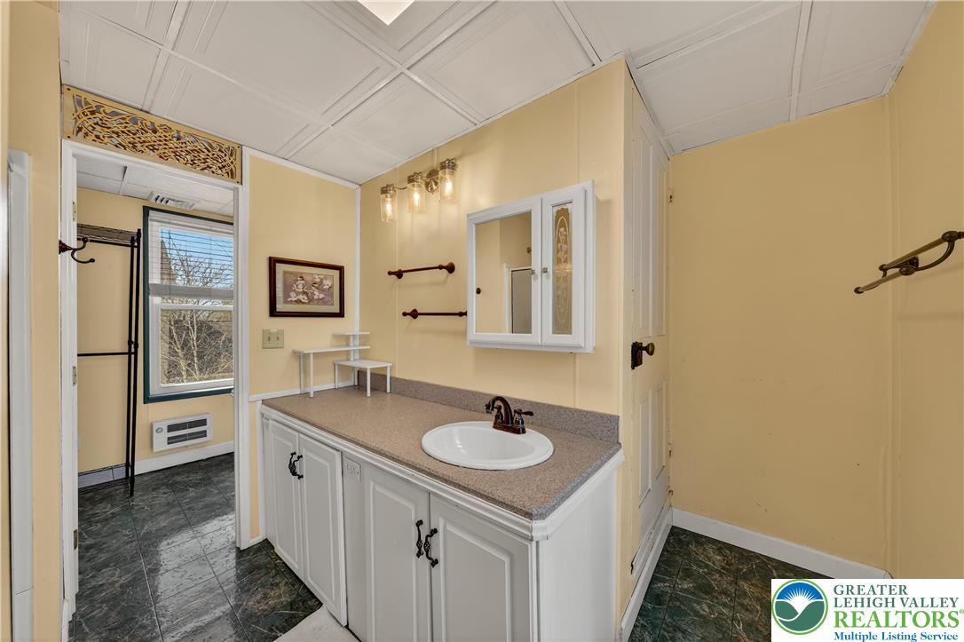 945 Main Street Bethlehem, PA 18018 - Photo 40 of 75 a bathroom with a sink a mirror and a shower