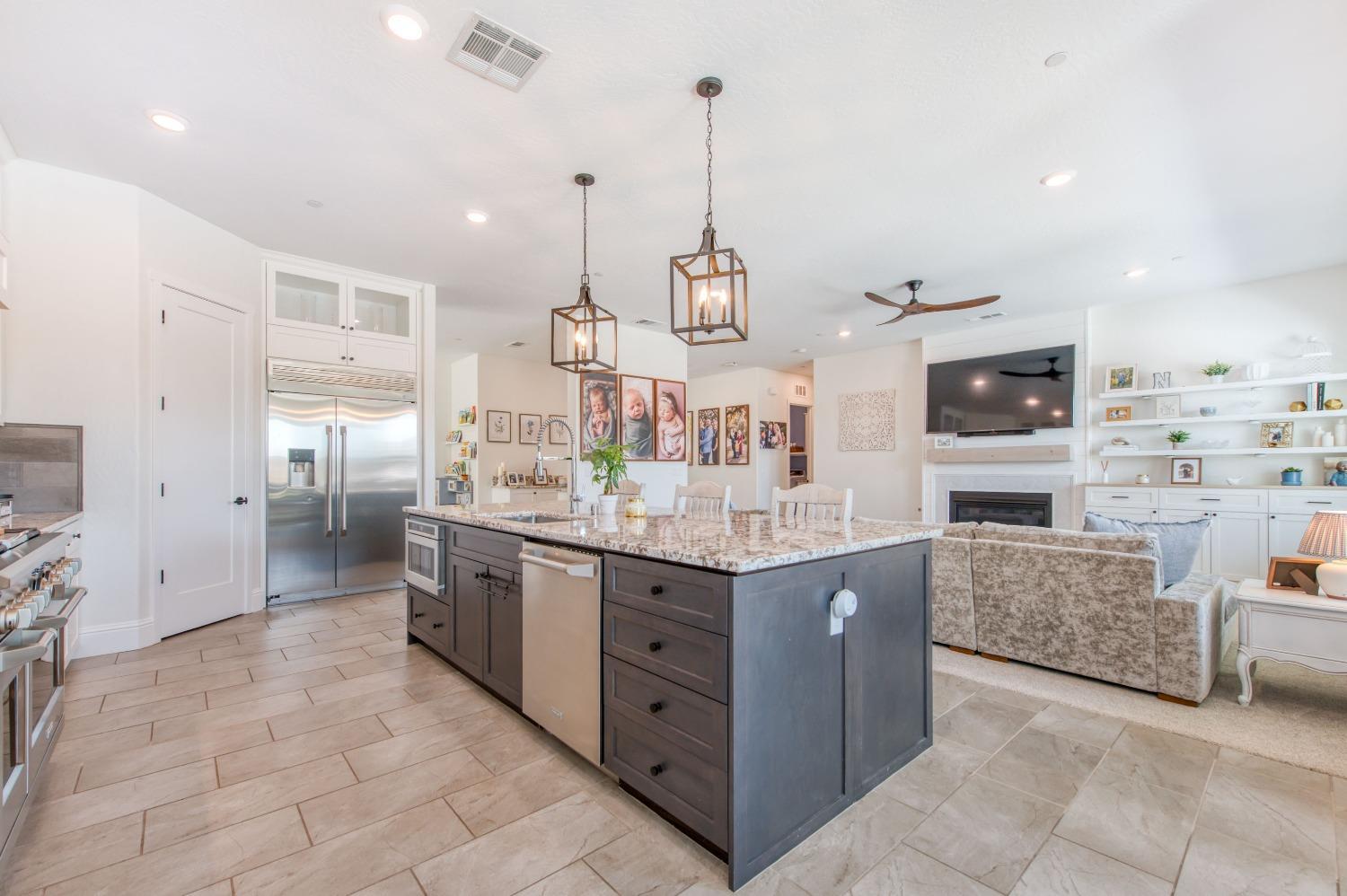 678 Ponderosa Way Madera, CA 93636 - Photo 15 of 38 a large kitchen with stainless steel appliances kitchen island granite countertop a sink and cabinets