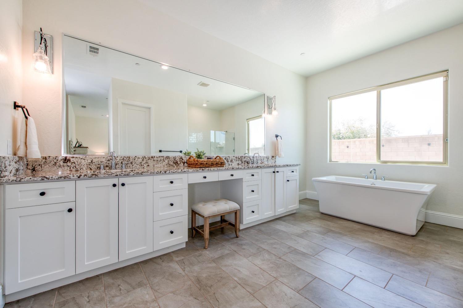 678 Ponderosa Way Madera, CA 93636 - Photo 27 of 38 a bathroom with a granite countertop sink mirror and a bathtub