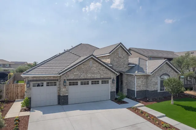 a view of a house with a yard and potted plants