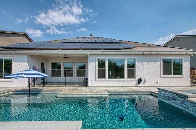 a view of a house with backyard and sitting area