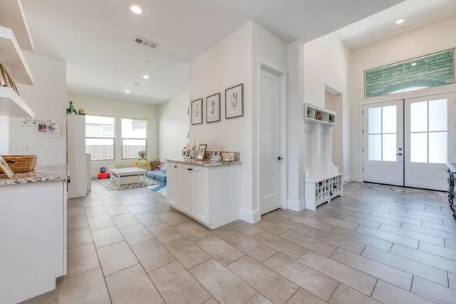 a large white kitchen with dishwasher and furniture