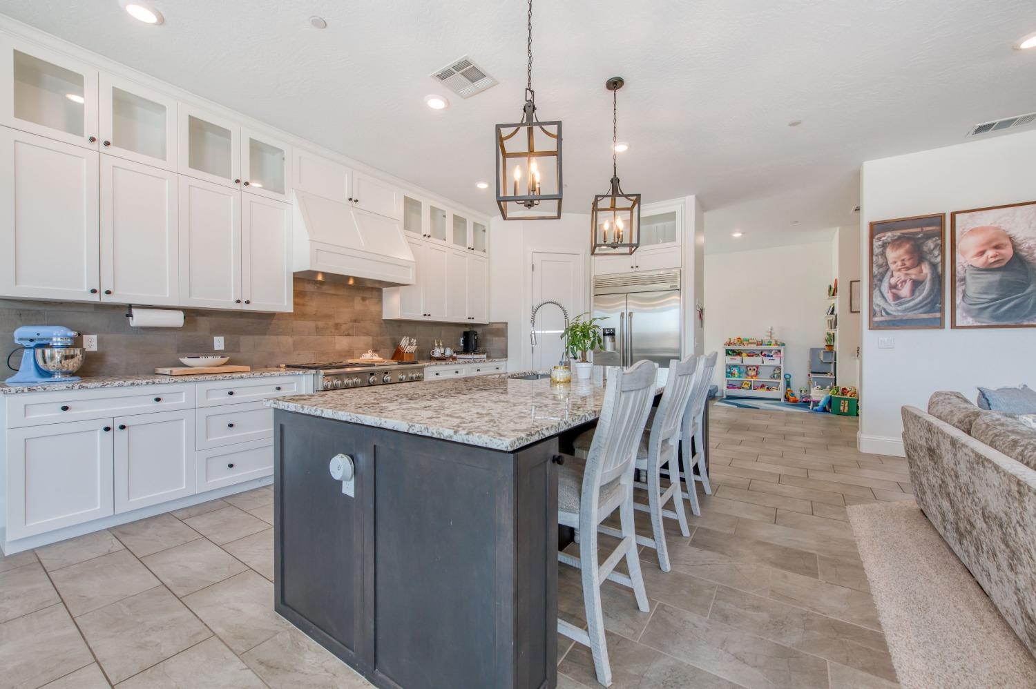 678 Ponderosa Way Madera, CA 93636 - Photo 10 of 38 a kitchen with granite countertop cabinets a table and chairs in it