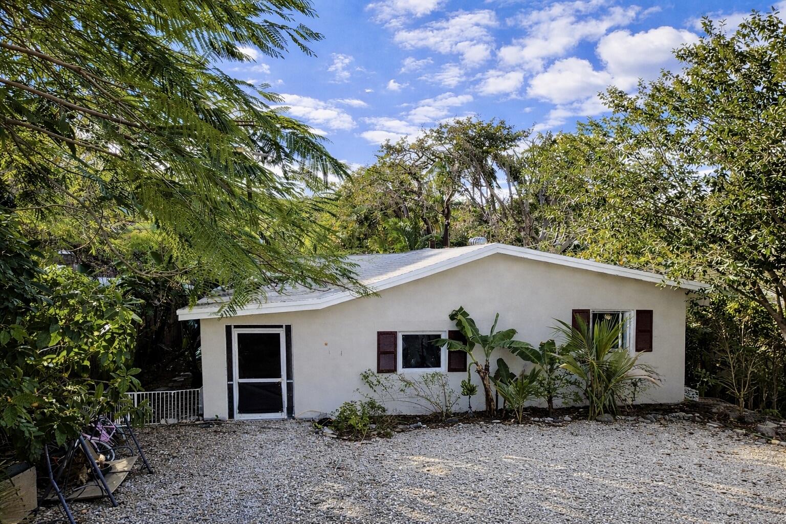 711 Sharon Place Key Largo, FL 33037 - Photo 1 of 38 a house that has a tree in front of it