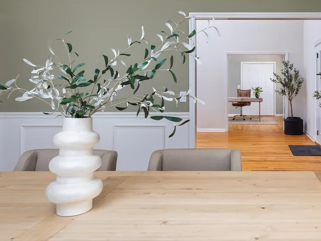 a kitchen with stainless steel appliances a dining table chairs refrigerator sink and cabinets