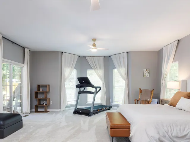 a bedroom with a bed a dresser and wooden floor